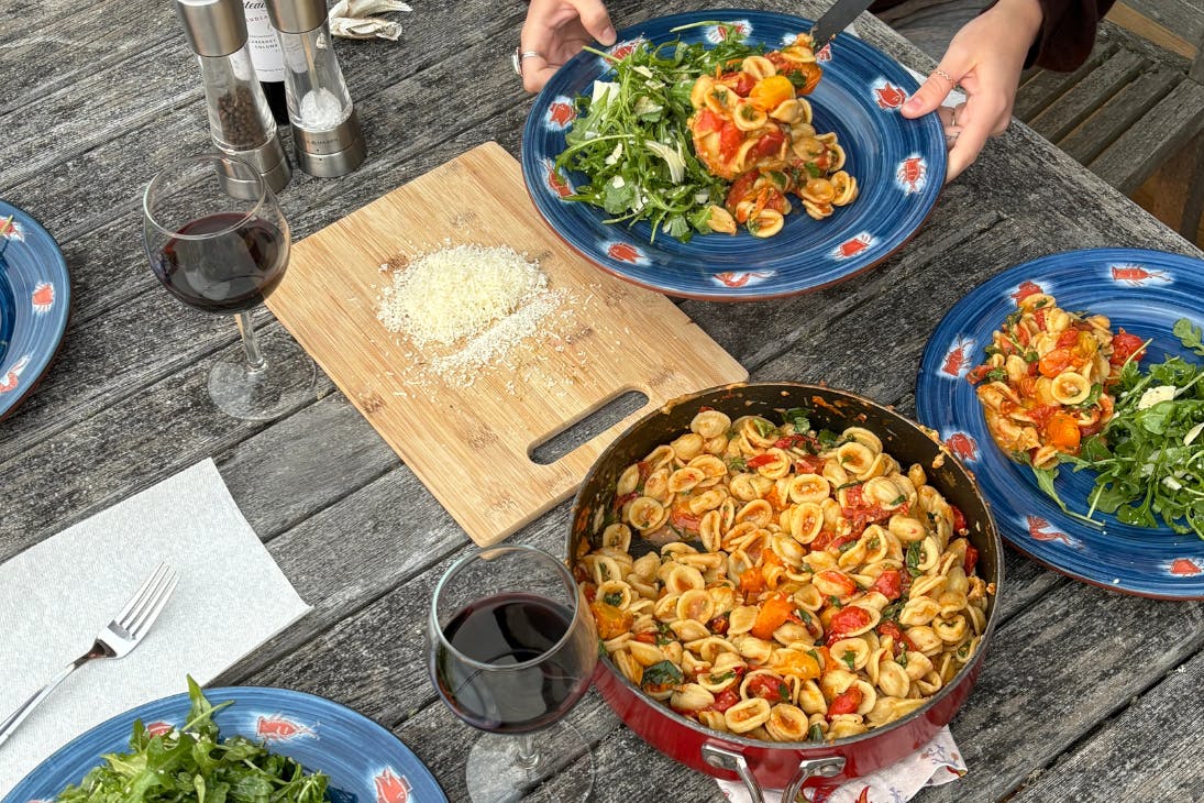 Home cooked pasta and salad on outdoor dining table